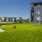 Dog-Friendly Apartments in Kansas City, KS - Switch - A Spacious Fenced Dog Park with Green Turf and View of Apartment Buildings.